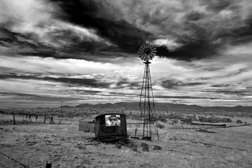 Windmill, water tank and strange poster, isolated ranch scene 