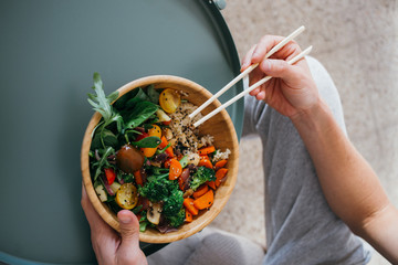Man with healthy lifestyle and green food choices eats fresh and delicious buddha bowl dish with nutrients and proteins, organic ecological vegetables and grains, vegan and vegeterian plate menu