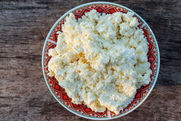 Homemade cottage cheese on old wooden table