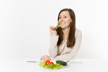 Vegan woman at table with leaves salad lettuce, vegetables on plate isolated on white background. Proper nutrition, vegetarian food, healthy lifestyle dieting concept. Advertising area with copy space