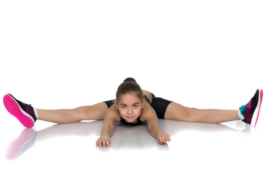 Girl gymnast perform the twine exercise.