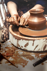Ceramics. The master on the potter's wheel produces a vessel of clay, undercutting the form.