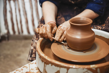 Ceramics. The master on the potter's wheel produces a vessel of clay, undercutting the form.
