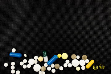 Fototapeta na wymiar Medicine theme, white tablets antibiotic pills. Pharmacy concept. Free space for text. Black background
