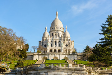 The basilica of the Sacred Heart of Paris under a blue sky in springtime seen from the bottom of...