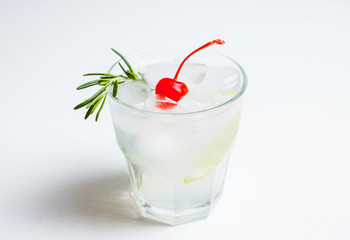 Bitter old-fashioned cocktail with lemon slice and cherry. Selective focus.