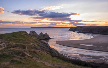 landscape image of three cliffs bay at sunset with the tide in  © stephm2506