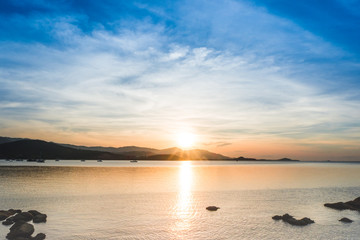 Beautiful sunrise and sunset with blue clouds over horizon clam blue sea and mountain background in morning and evening.