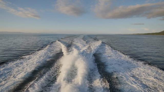 Background of water trail foaming behind a ferry boat.