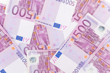 Pile of five hundred euro bills placed on table for financial background.