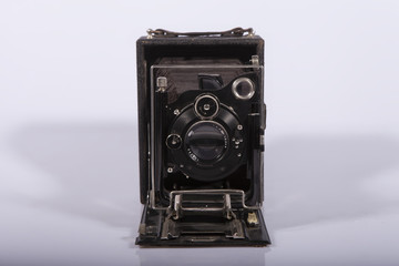 Fototapeta premium antique Vintage medium format camera with a sliding fur isolated on a light background