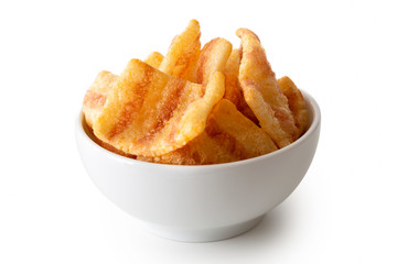 Extruded bacon flavoured chips in white ceramic dish isolated on white.