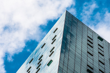 Angle glass facades of a window with the windows open transom, air vents of financial skyscrapers, a corner of a building close-up.