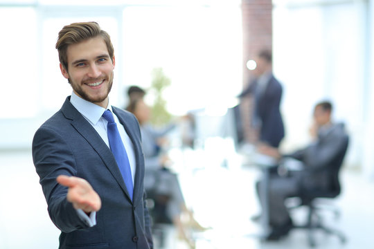 Businessman with hand in a welcoming gesture at the office