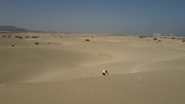 Man Climbing Desert Sand Dune