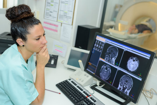 female doctor looking at patient undergoing ct scan