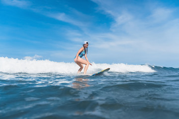 woman in swimming suit surfing in ocean