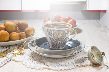 Cup of tea and donuts on wooden table