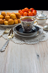 Cup of tea and donuts on wooden table