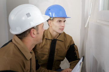 Workmen inspecting window