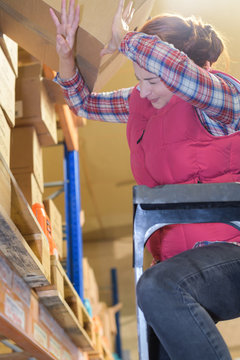 cardbox falling over female worker in the warehouse