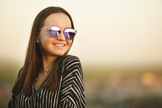 portrait of a young smiling girl in sunglasses with reflective glasses.