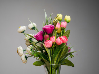 Flower bouquet in jar with gray background.