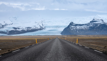 Road leading towards huge glacier and mountains in Iceland
