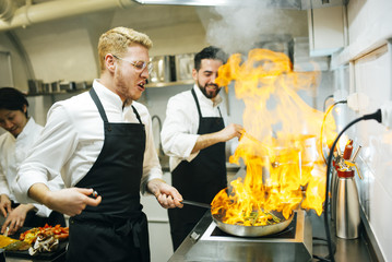 Chefs cooking flambe in the kitchen