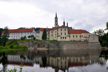 Fototapeta na wymiar Vyssi Brod cistercian monastery in south Bohemia reflected in water, Czech republic.