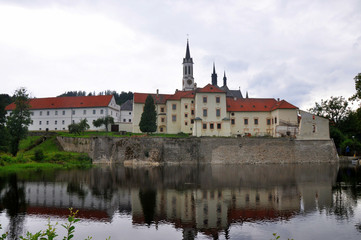Fototapeta premium Vyssi Brod cistercian monastery in south Bohemia reflected in water, Czech republic.