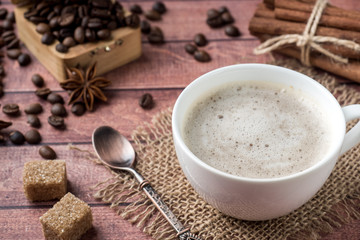 White coffee Cup and saucer with milk foam and cane sugar cinnamon Anise Coffee beans