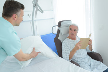nurse next to a patient reading a book