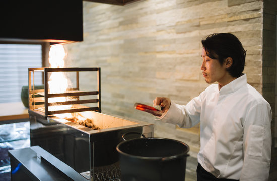 Chef cooking in restaurant preparing coal