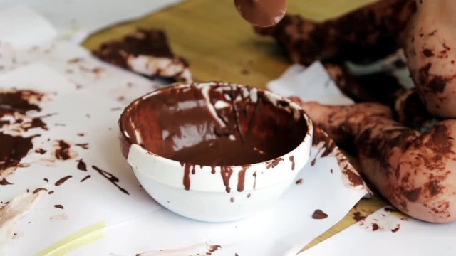 baby painting with hands with chocolate