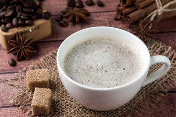 White coffee Cup and saucer with milk foam and cane sugar cinnamon Anise Coffee beans