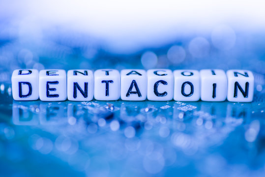Word DENTACOIN formed by alphabet blocks on mother cryptocurrency