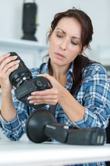 female photographer adjusting a camera tripod