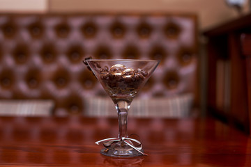 gold wedding rings lie in a glass with coffee beans.