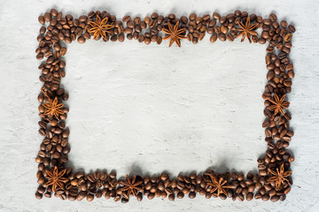 Frame of coffee beans and star Anfisa on gray concrete background Copy space