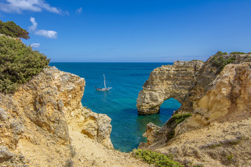 Fototapeta na wymiar Arcos del acantilado de roca en la playa de Marinha y agua de mar de color turquesa en la costa de Portugal en la región de Algarve 