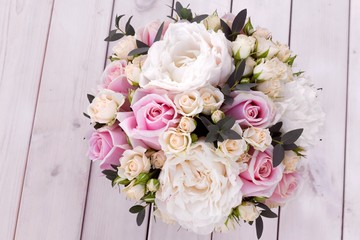 Bouquet for bride from different flowers on white wooden background.