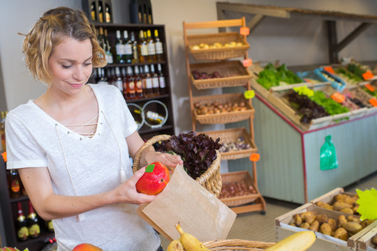 smiling female holding fresh peper in hands in food store
