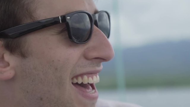 Cool guy wearing sunglasses on a boat during his adventure travel vacation