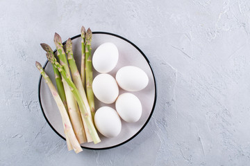 Preparation of asparagus and eggs. Simple products for a healthy breakfast. Space for text Background for a recipe.