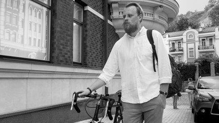 Black and white portrait of young hipster man walking on street