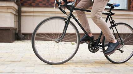 Fototapeta na wymiar Closeup image of male feet turning retro bicycle pedals