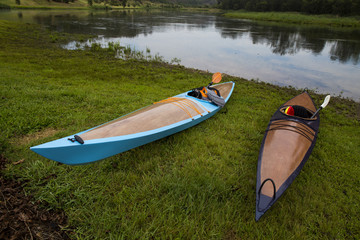 Kayaks are sitting on the ground, ready to ride on