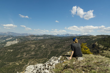 Woman enjoing a panoramic view on the snowy picked mountains in French Provence region.