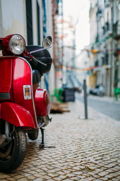 Red scooter parked in a street of Lisbon